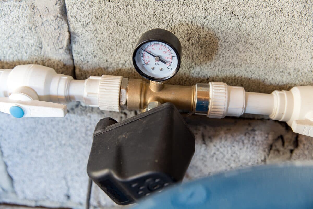 Well pressure switch mounted next to a pressure tank and gauge.